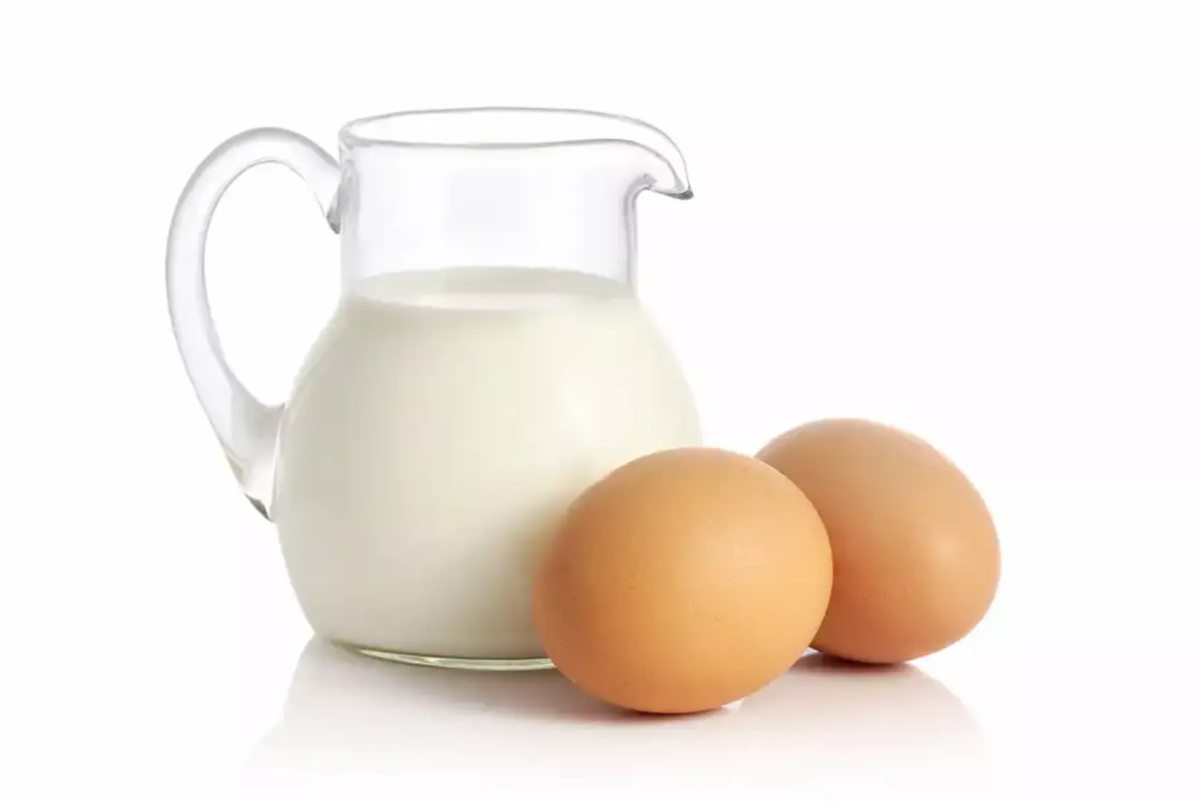 Eine Glaskanne mit Milch und zwei Eier