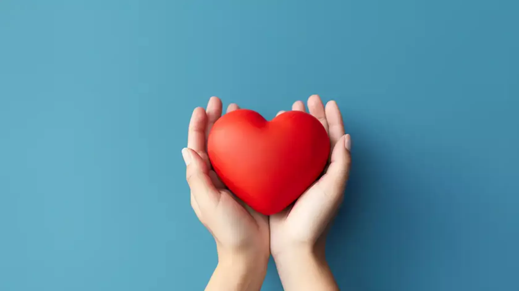 Zwei Hände halten ein rotes Herz.