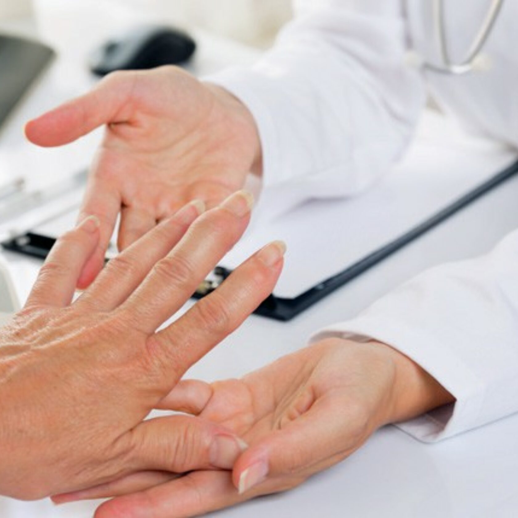 Arzt begutachtet die Hände einer Rheumapatientin.