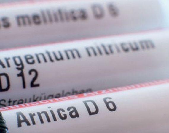 Behälter für Globuli sind zu sehen, die in einem Mäppchen stecken - Apis mellifica D6, Argentum nitricum D12, Arnica D6.