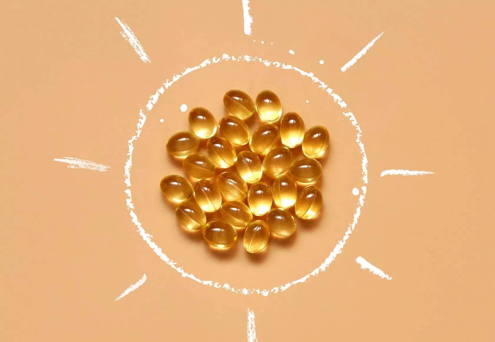In einer Strichzeichnung der Sonne sind glänzende Vitamin-D-Kapseln angeordnet.