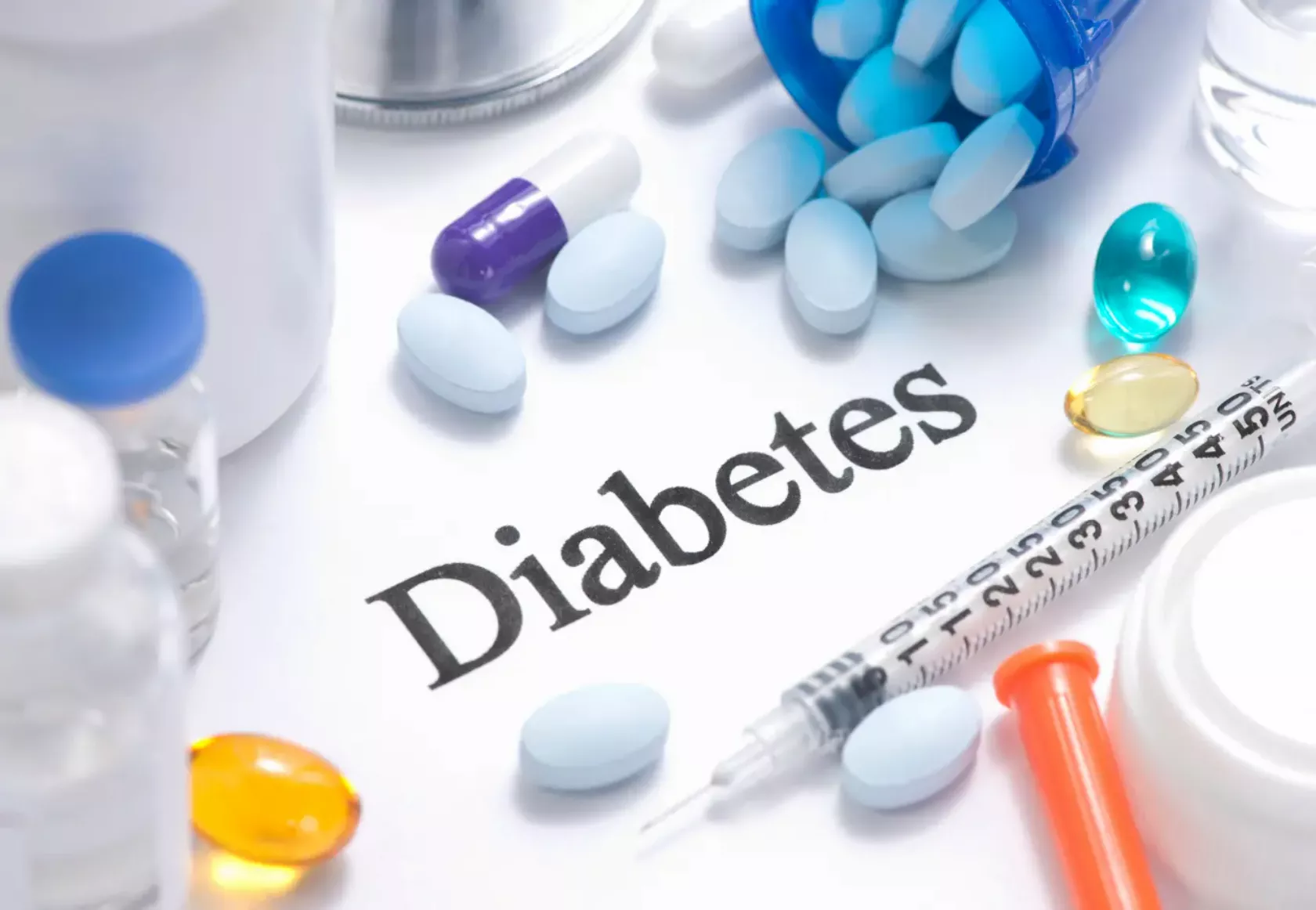 Um den Schriftzug Diabetes sind verschiedene Tabletten, Kapseln und Ampullen angeordnet.