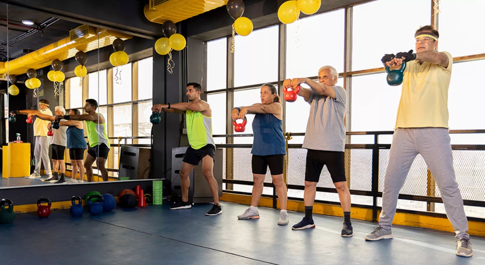 Schlaganfall-Patienten in einer Sporthalle trainieren im Stehen mit Gewichten.